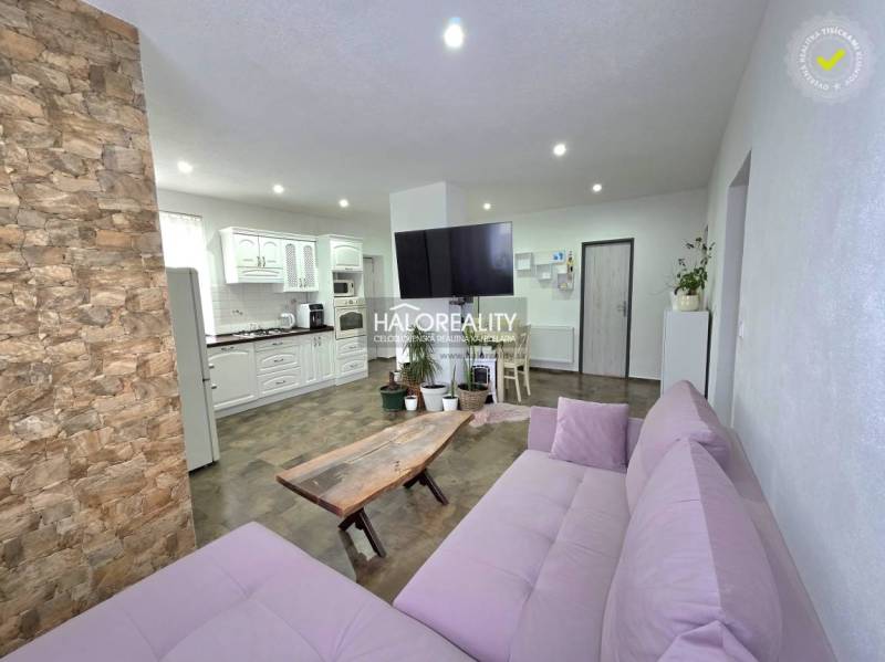 Living room of a family house with stone cladding and a kitchenette.