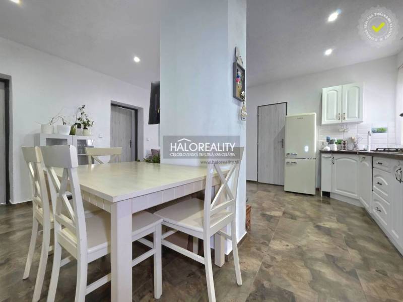 A kitchen in a family house with a wooden decor floor and white furniture.