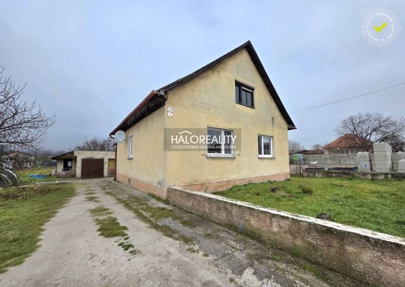 A family house in Čereňany with a garage, green lawn, and driveway.