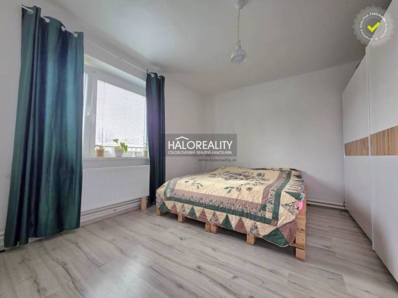 Bedroom with wood-patterned flooring, a bed, and a built-in wardrobe in a family house.