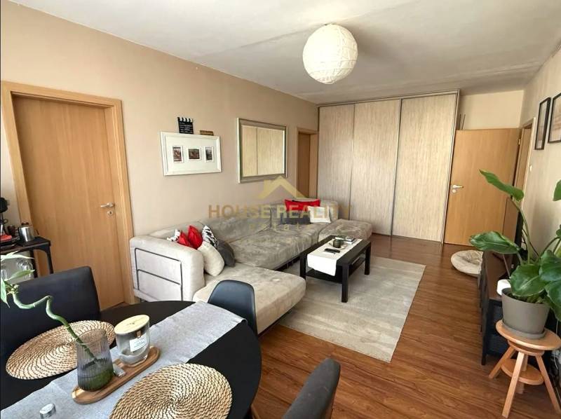 Living room in a 3-room apartment with a sofa and a table, floor with wooden decor.