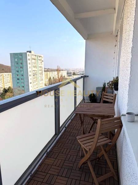 The balcony of a 3-room apartment on Púpavova Street in Bratislava - Karlova Ves with a wooden floor decor.