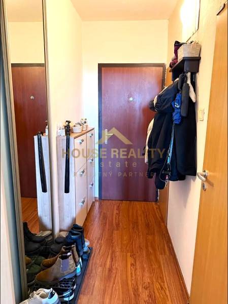 Entrance hallway in a 3-room apartment with a wood-patterned floor and practical furniture.