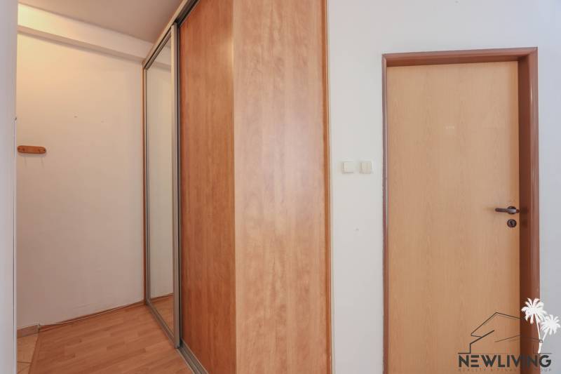 Interior of a 2-room apartment with a sliding wardrobe and a floor with a wooden decor.