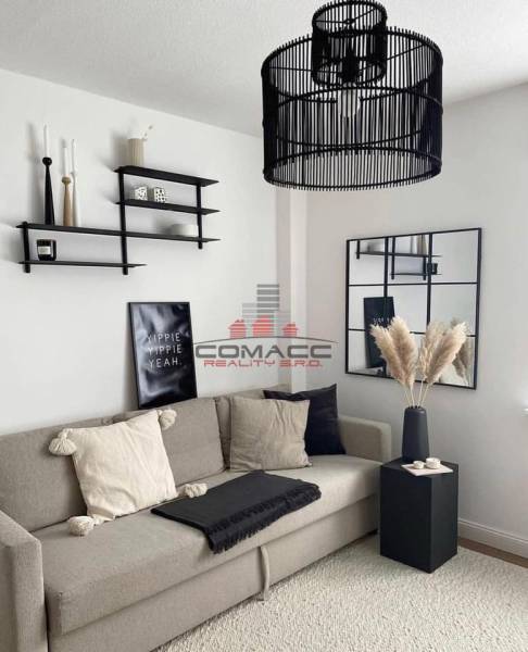 Living room in a family house with a comfortable sofa, decorative shelves, and a modern chandelier.