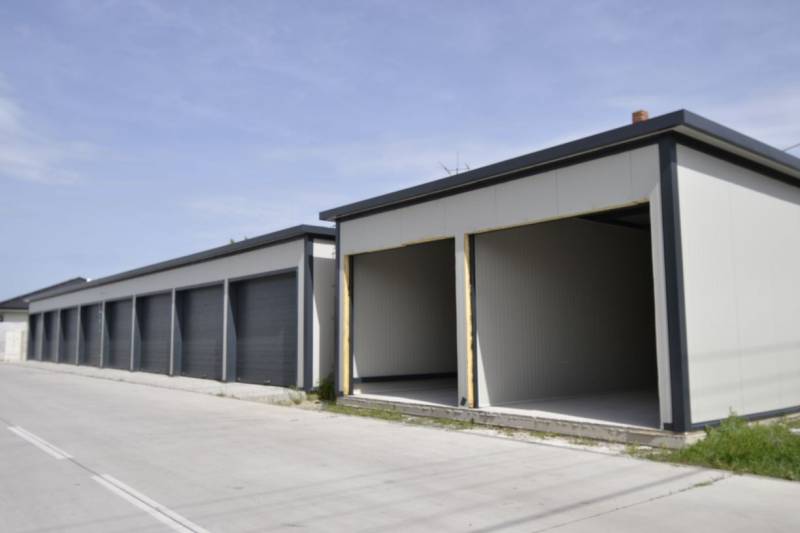 Garages in Michal na Ostrove with gray facades and open gates.