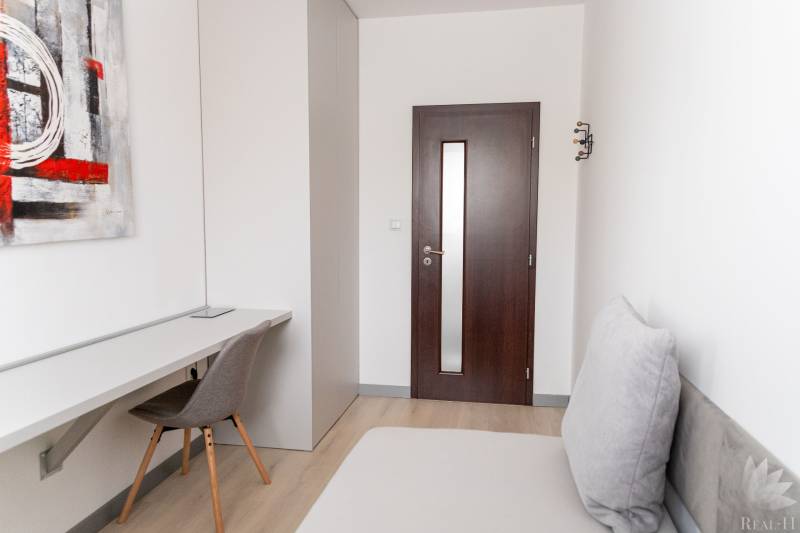 A workspace in a 4-room apartment with a wooden decor floor and modern art.