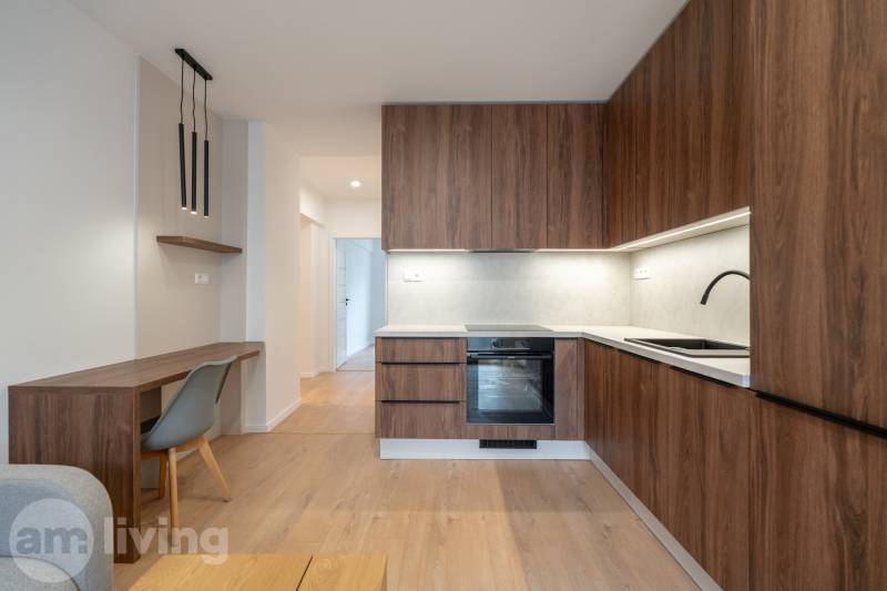 A kitchen in a 3-room apartment with wooden decor and stylish lighting.
