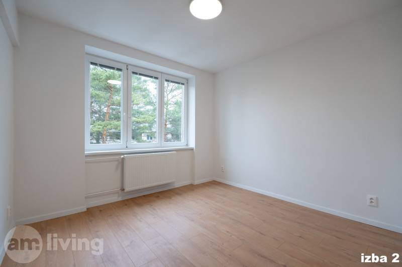 A bright room with white walls and a floor with a wood decor in a 3-room apartment.