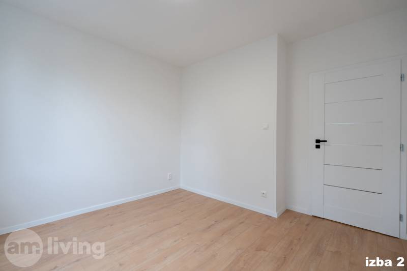 A room in a 3-room apartment with a wooden decor floor and white walls.