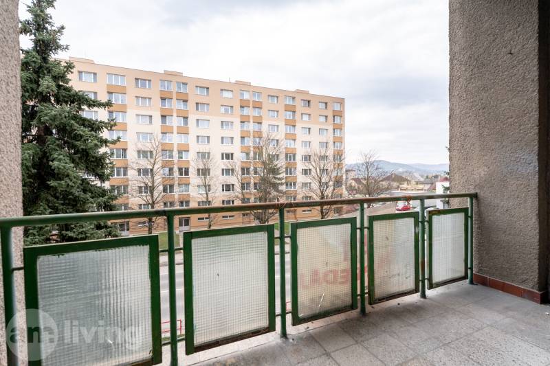 The balcony of a 3-room apartment in Dubnica nad Váhom with a view of the apartment building and greenery.