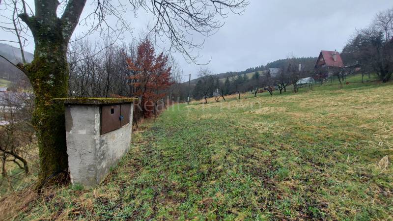 Green recreational plots in Púchov with views of the surrounding hills and trees.