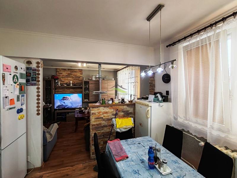 Dining room in a 4-room apartment with a wood-patterned floor and a television.