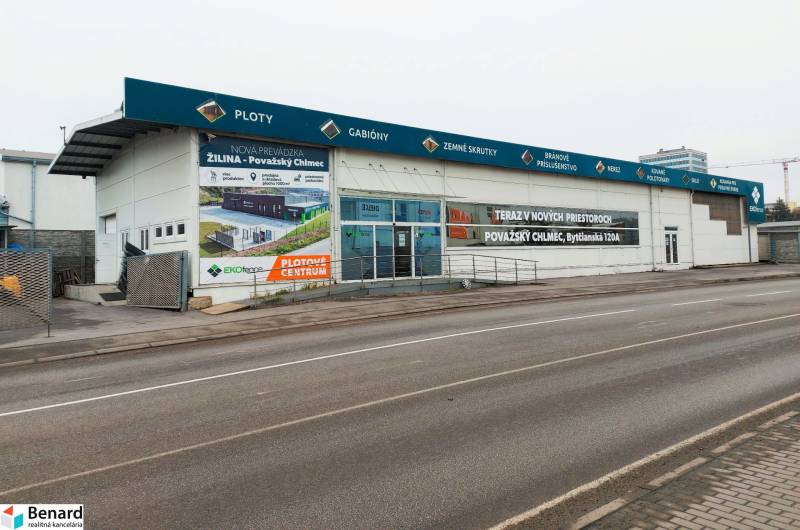 Commercial spaces on Kamenná Street in Žilina with advertising signs and an empty parking lot.