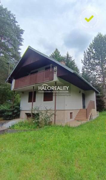 A cottage in Borský Svätý Jur surrounded by greenery and forest, with a balcony and a garden.