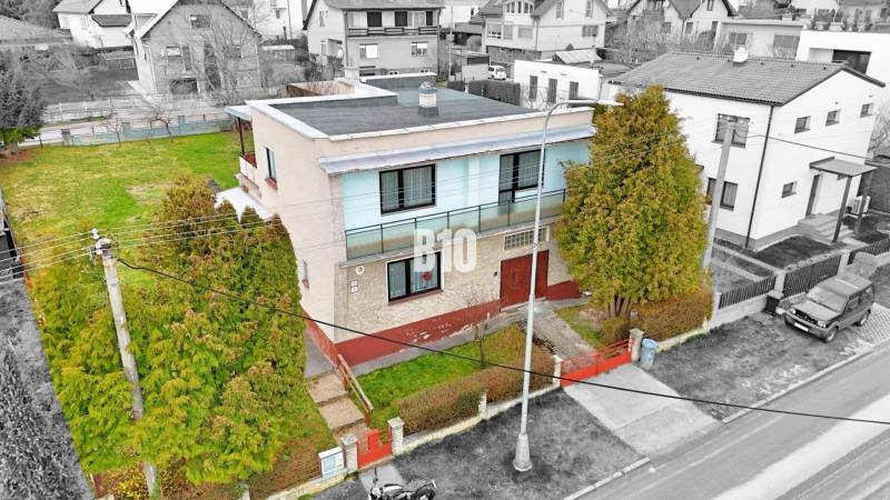A family house in Martin with a flat roof, a garden, and surrounding houses.