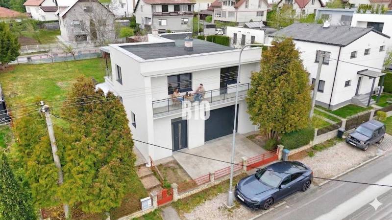 A family house in Martin with a balcony, garage, and surrounding greenery.