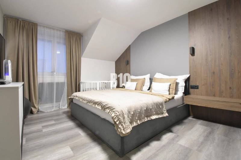 Bright bedroom with a comfortable bed in a 4-room apartment, floor with wood decor.