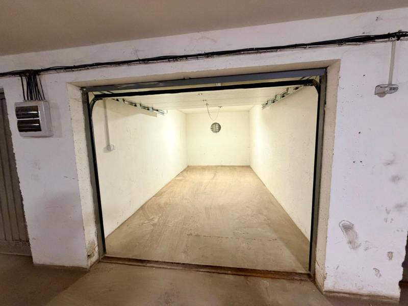 Empty garages with concrete floors and simple lighting.