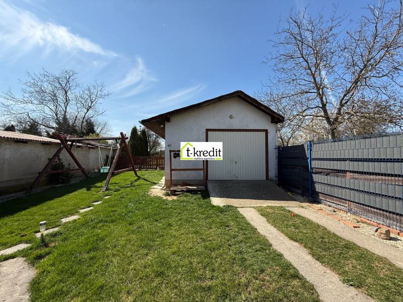 A family house in Zlaté Moravce with a lawn, a swing, and a garage on the property.