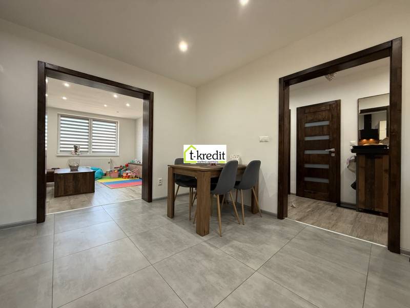 Interior of a family house with a dining table, children's room, and decorative flooring.