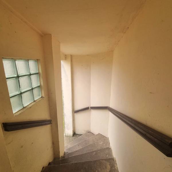 A staircase inside a family house with a glass wall and railing.