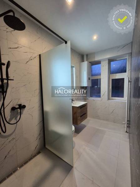 A bathroom in a 2-room apartment with a bathtub and a shower, tiles with marble imitation.