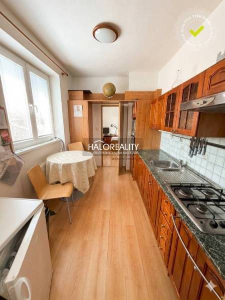 A kitchen in a 3-room apartment with a wooden decor floor and a dining table.