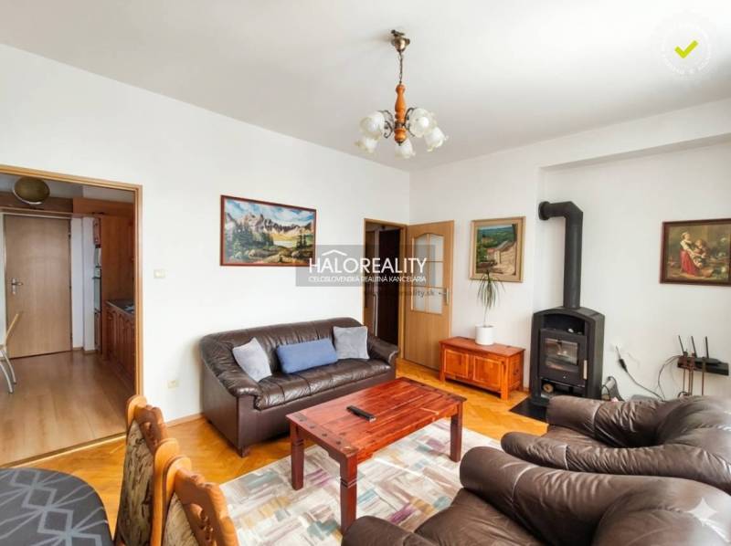 A bedroom in a three-room apartment with a wood-patterned floor and a double bed.