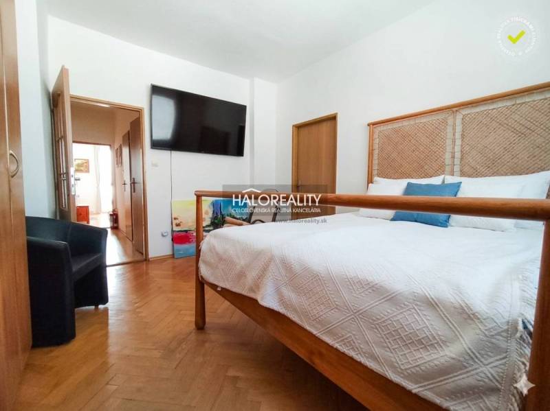 A bathroom in a 3-room apartment with a washing machine and a bathtub behind a curtain.