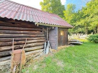 A wooden cottage in Horná Mariková, with a tin roof and surrounded by greenery.