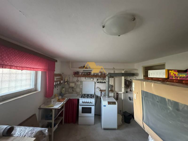 A kitchen in a family house with an older stove and bright red curtains.