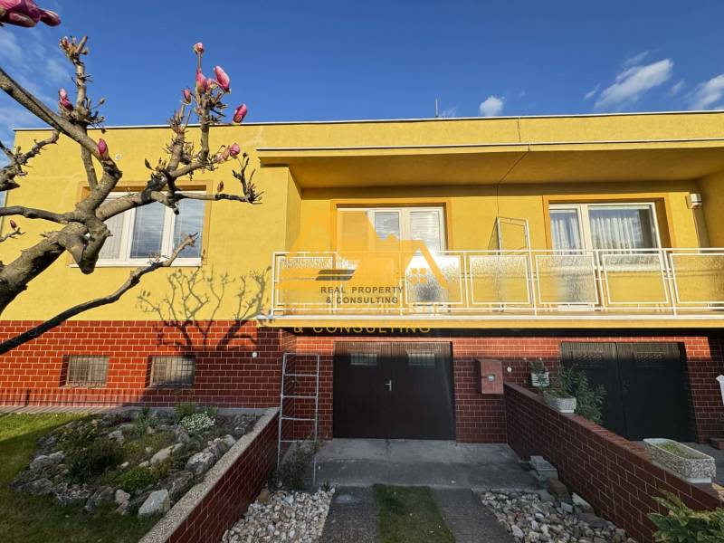 A family house in the city of Nové Zámky on Nové Zámky Street with a yellow facade and a garden.