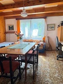 Living room in a family house with a dining table and flowers on it.