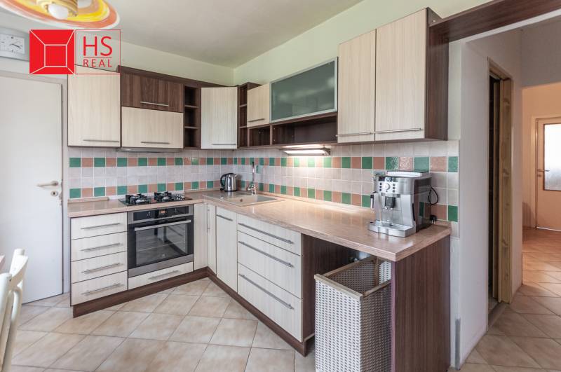 A kitchen in a 3-room apartment with a functional unit and tiled wall cladding.