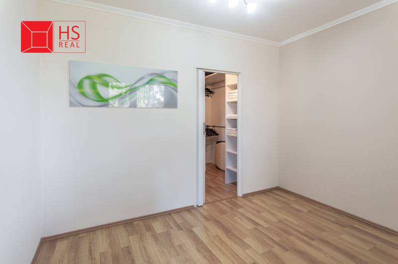 A room with a wooden floor decor and a built-in wardrobe in a 3-room apartment.