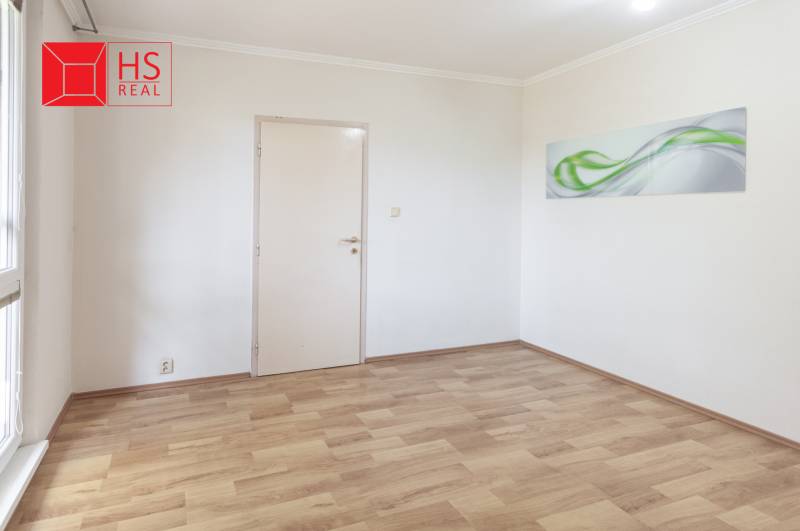 An empty room with a decorative painting and a wooden-patterned floor in a 3-room apartment.