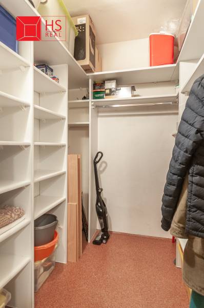 A wardrobe in a 3-room apartment with shelves and space for hanging clothes.