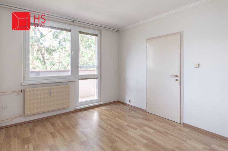 A room in a 3-room apartment with a wooden decor floor and large windows.