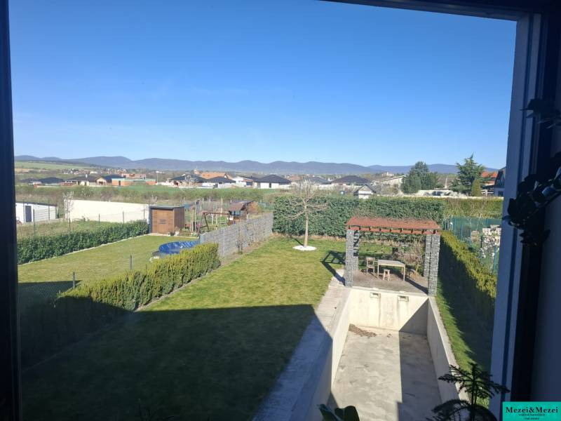 The garden of a family house in Zvončín with a gazebo and a swimming pool, overlooking the hills.
