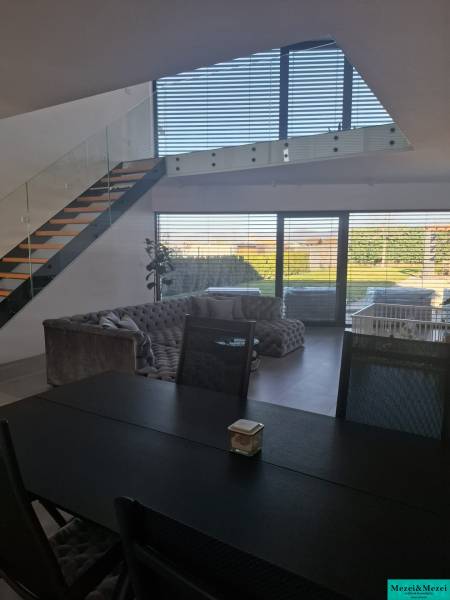 Dining table and staircase in a family house with a view of the garden.