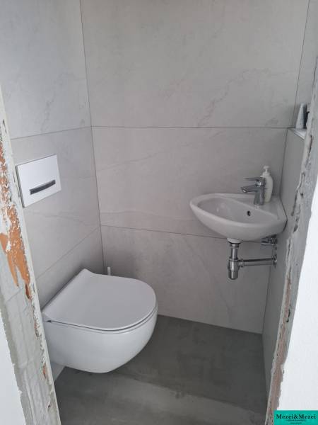 A small bathroom in a family house with a washing machine and a sink.
