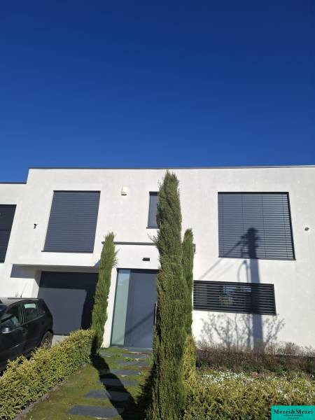 A family house in Zvončín with a minimalist facade and a landscaped front garden.