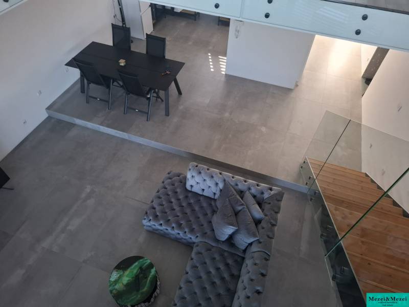 Interior of a family house with a view of the dining table, sofa, and staircase.