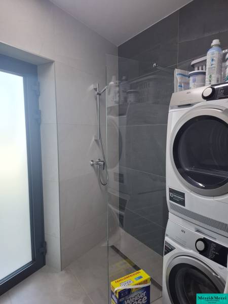 Bathroom in a family house with a washing machine and a shower.