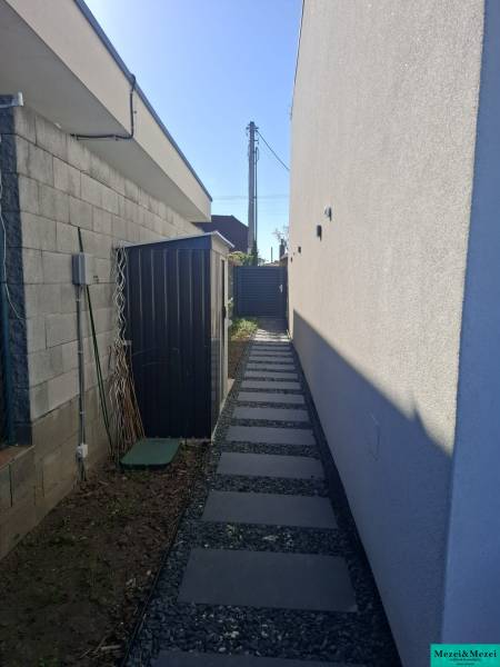 A narrow side path with gravel in a Family House in Zvončín.