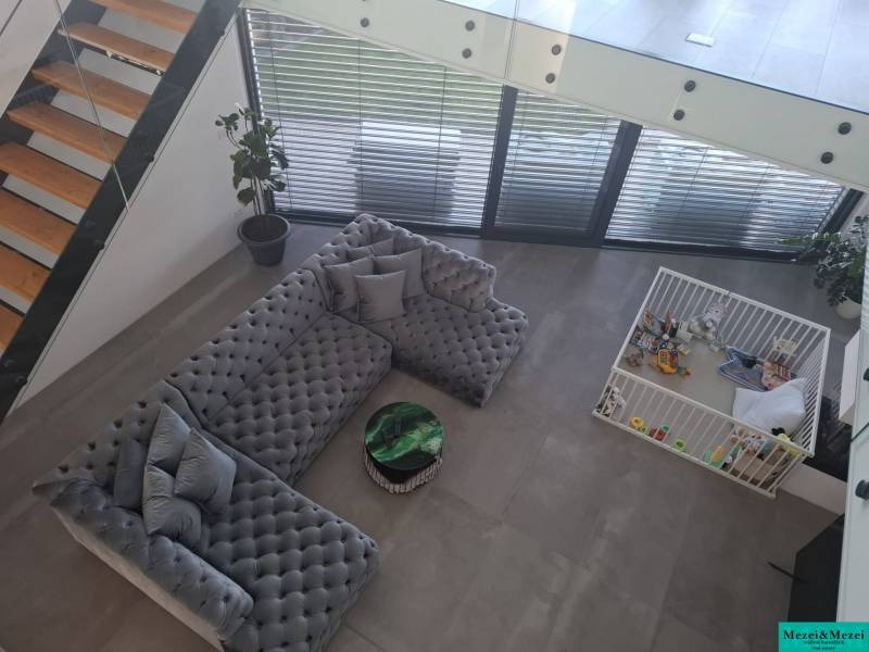 Living room in a family house with a large sofa, children's corner, and stairs.