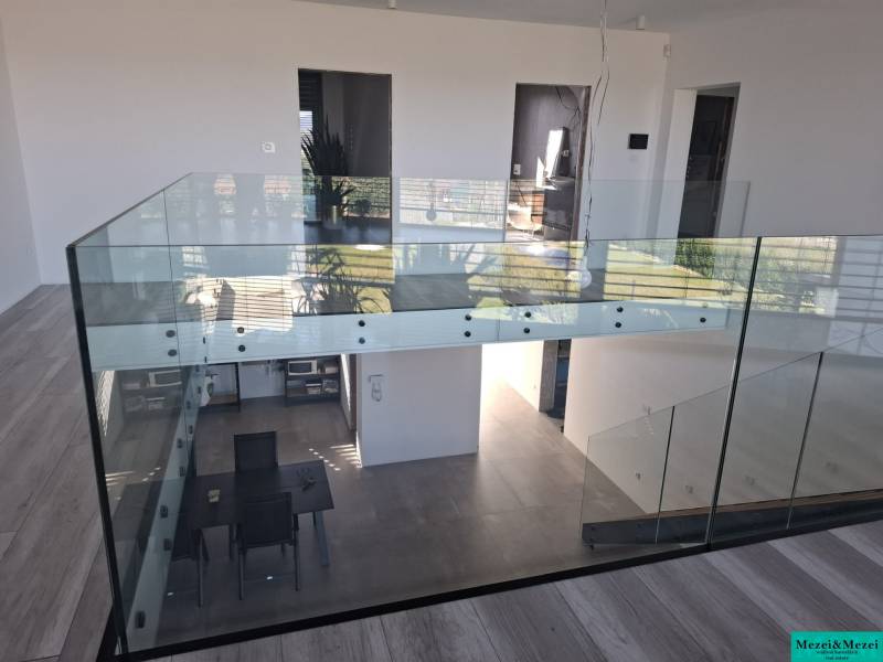 Interior of a family house with glass railings and flooring with a wooden decor.