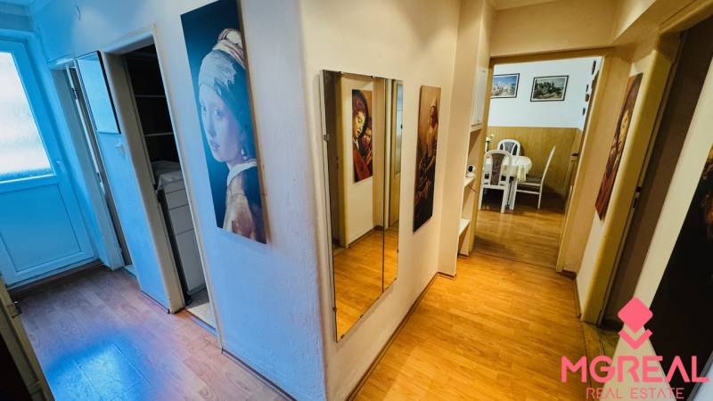A hallway with a mirror and a wooden decor floor in a 3-room apartment.
