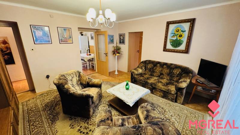 Living room with armchairs, a sofa, and a carpet in a 3-room apartment.